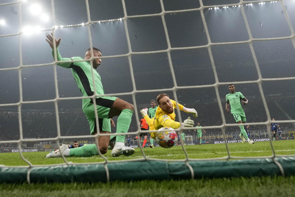 Atletico Madrid's goalkeeper Jan Oblak jumps for the ball as Inter Milan's Marko Arnautovic scores his side's opening goal during the Champions League, round of 16, first leg soccer match between Inter Milan and Atletico Madrid, at the San Siro stadium in Milan, Italy, Tuesday, Feb. 20, 2024. (AP Photo/Luca Bruno)