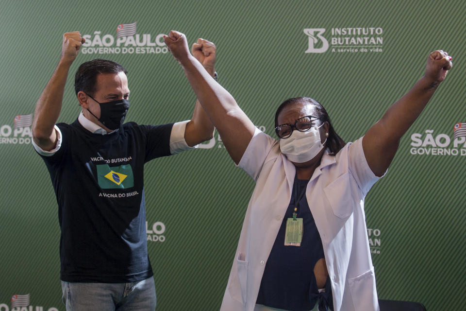 Nurse Monica Calazans, 54, and the Governor of Sao Paulo Joao Doria celebrate after she got her shot of the COVID-19 vaccine produced by China’s Sinovac Biotech Ltd, at the Hospital das Clinicas in Sao Paulo, Brazil, Sunday, Jan. 17, 2021. (AP Photo/Carla Carniel)
