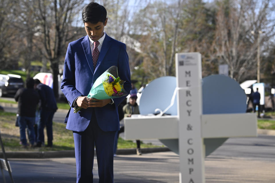 Alexander Reddy, 17, prays at an entry to Covenant School, Tuesday, March 28, 2023, in Nashville, Tenn., which has become a memorial to the victims of Monday's school shooting. (AP Photo/John Amis)