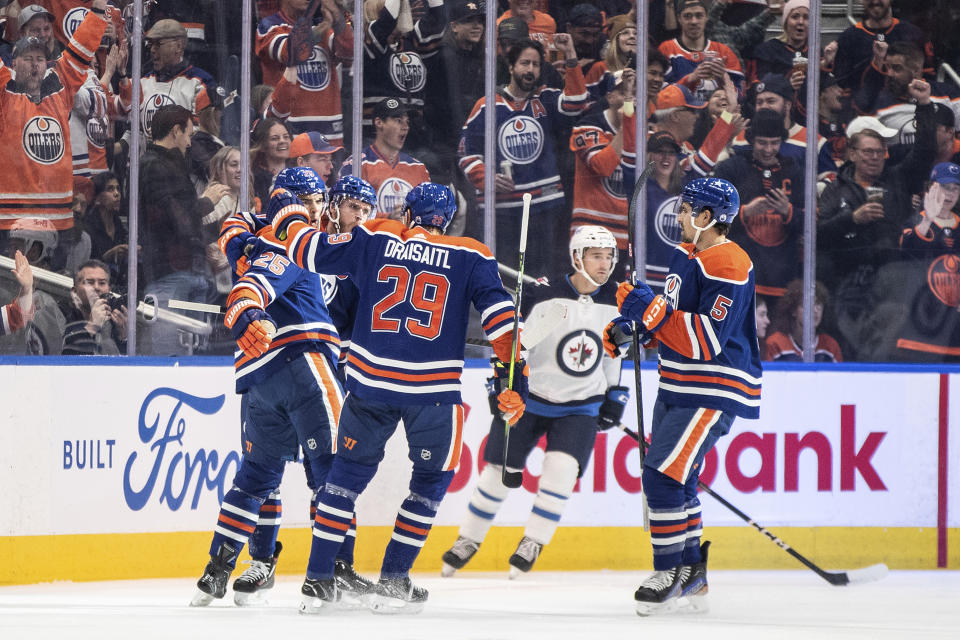 Edmonton Oilers' Cody Ceci (5), Leon Draisaitl (29), Darnell Nurse (25) and Connor McDavid celebrate a goal against the Winnipeg Jets during the first period of an NHL hockey game in Edmonton, Alberta, Saturday, Oct. 21, 2023. (Jason Franson/The Canadian Press via AP)