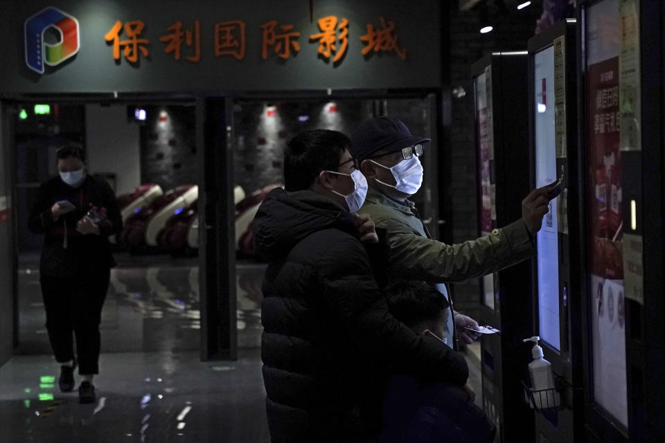 People wearing face masks to help curb the spread of the coronavirus collect their movie tickets at Poly Cinema in Beijing on Thursday, Feb. 25, 2021. With coronavirus well under control in China and cinemas running at half capacity, moviegoers are smashing China's box office records, setting a new high mark for ticket sales in February, with domestic productions far outpacing their Hollywood competitors. (AP Photo/Andy Wong)