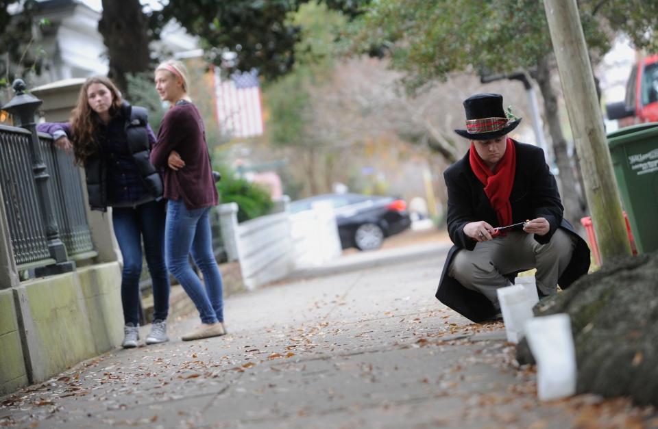 Scott Maxey dresses as a 19th century lamplighter as he lights the sidewalk luminaries by the Latimer House on South Third Street during the Old Wilmington by Candlelight Tour in the early 2010s.
