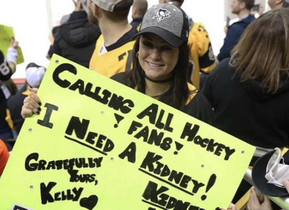 Kelly Sowatsky holding the sign that ended up saving her life. (Twitter//@penguins)