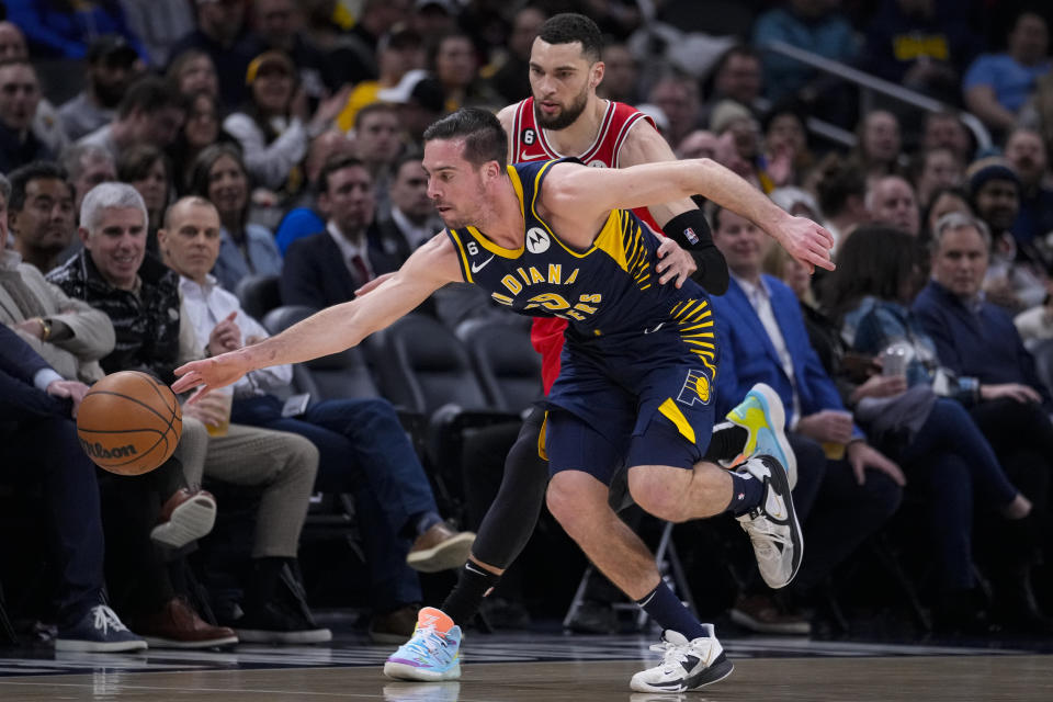 Indiana Pacers guard T.J. McConnell (9) picks up a loose ball in front of Chicago Bulls guard Zach LaVine (8) during the first half of an NBA basketball game in Indianapolis, Tuesday, Jan. 24, 2023. (AP Photo/Michael Conroy)