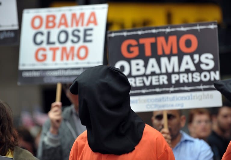 A protester at a rally in New York's Times Square on April 11 to demand the closure of the Guantanamo facility. Behind the walls of the prison on the arid hills of Guantanamo, the men lost in indefinite detention seek to draw attention to an unprecedented hunger strike a third of them are waging