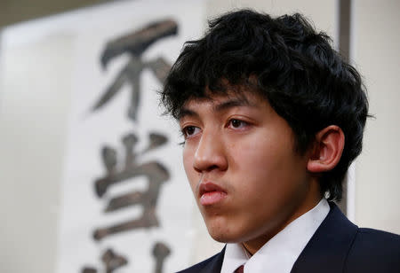 Utinan Won, a 16-year-old high school student living in Japan without a visa, attends a news conference in Tokyo, Japan, December 6, 2016. The characters on the wall are part of banner which reads, ' Unjust ruling'. REUTERS/Kim Kyung-Hoon