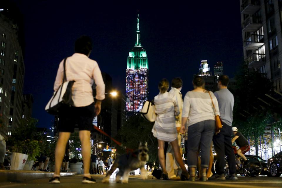 People watch as an image is projected onto the Empire State Building as part of an endangered species projection to raise awareness, in New York August 1, 2015. (REUTERS/Eduardo Munoz)