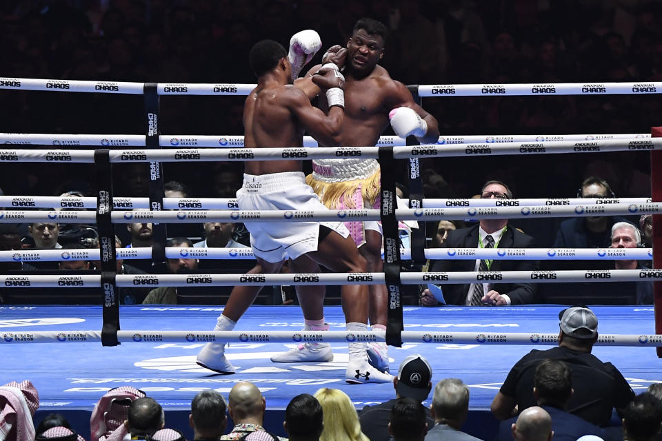 British former world champion Anthony Joshua, left, and MMA fighter Francis Ngannou fight during the heavyweight boxing showdown at Kingdom Arena in Riyadh, Saudi Arabia, Saturday, March 9, 2024. (AP Photo)
