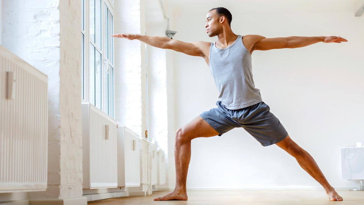  Man practicing yoga at a studio. 