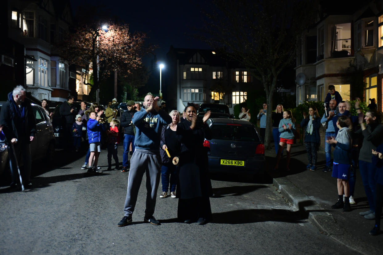 People in Woodford Green, London, join in a national applause for the NHS from their doorsteps, windows and balconies to show their appreciation for all NHS workers who are helping to fight the Coronavirus.