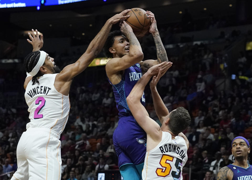 Charlotte Hornets guard James Bouknight (2) drives to the basket as Miami Heat guards Gabe Vincent (2) and Duncan Robinson (55) defend during the first half of an NBA basketball game Thursday, Nov. 10, 2022, in Miami. (AP Photo/Marta Lavandier)