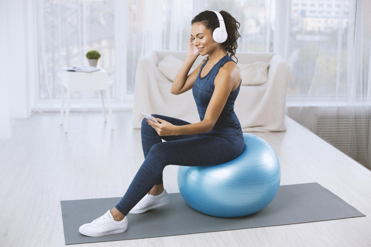 Mujer en Home office con tableta y pelota yoga. Foto: Getty Image.