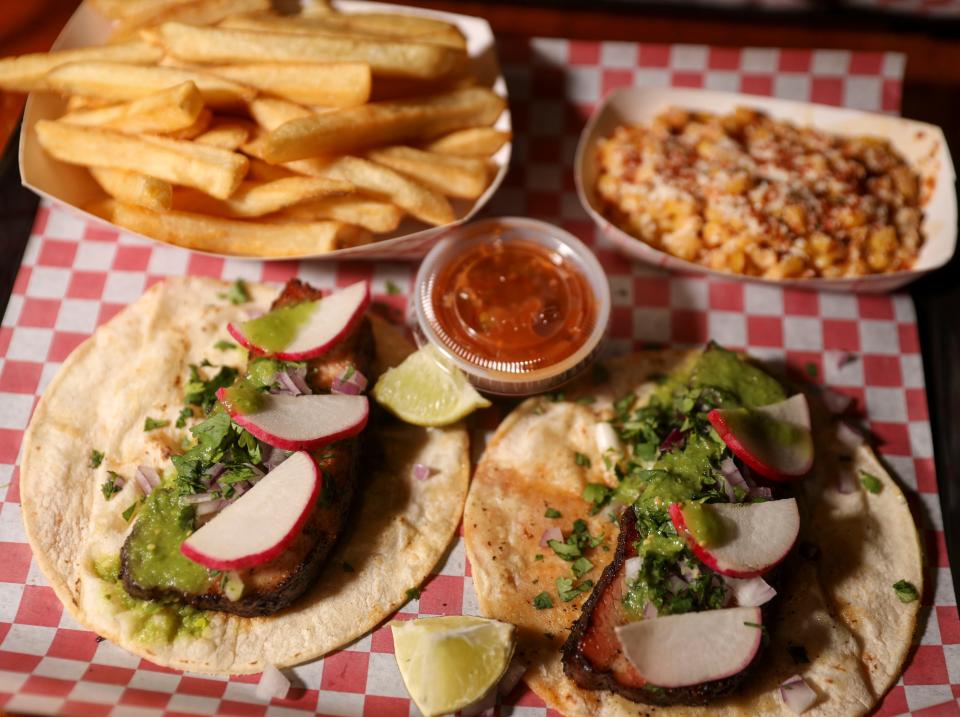 Inferno's pork belly tacos are served with fries and esquite.
