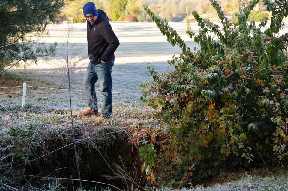 Chris Corl, the city's director of Community and Regional Entertainment Facilities, walks above a sinkhole that formed on the Municipal Golf Course October 20, 2022.