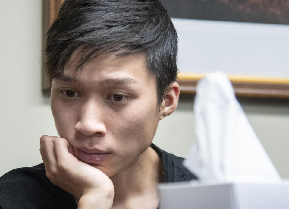 Yingying Zhang's brother Zhengyang Zhang, Listens during a press conference at lawyer Steve Beckett's law office on Wednesday, August 7 2019 Urbana, Ill. The father of the slain scholar who begged his daughter's killer to reveal what he did with her remains so that they could be returned to China for burial says his family now understands that recovering them may be impossible. The father of a slain Chinese scholar who begged his daughter's killer to reveal what he did with her remains said Wednesday that after learning her dismembered body might be in plastic bags buried in a landfill under mounds of garbage, he understood that his family may never get to bury her back home in China. (Robin Scholz/The News-Gazette via AP )