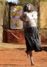 A local aboriginal woman performs a welcome dance for Britain's Prince William and Kate, the Duchess of Cambridge, at the Uluru Cultural Center at Yulara, Uluru Australia, Tuesday, April 22, 2014. (AP Photo/Rob Griffith)