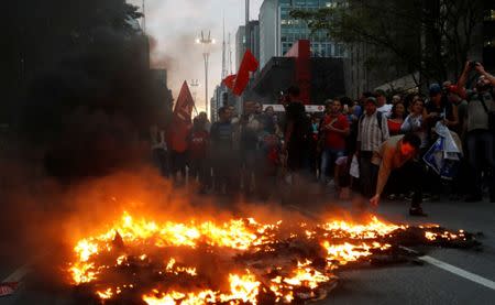 Demonstrators prepare a burning barricade during a protest against President Michel Temer's proposal reform of Brazil's social security system in the general strike in Sao Paulo, Brazil, June 30, 2017. REUTERS/Leonardo Benassatto