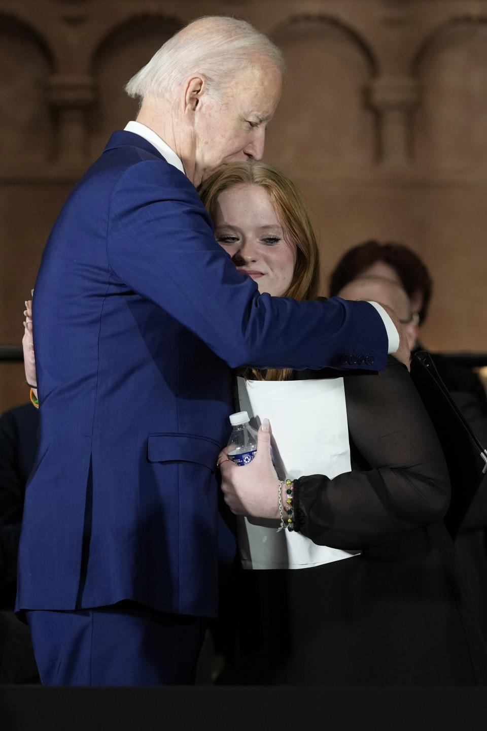 President Joe Biden hugs Sandy Hook survivor Jackie Hegarty, who introduced him, during an event in Washington, Wednesday, Dec. 7, 2022, with survivors and families impacted by gun violence for the 10th Annual National Vigil for All Victims of Gun Violence. (AP Photo/Susan Walsh)