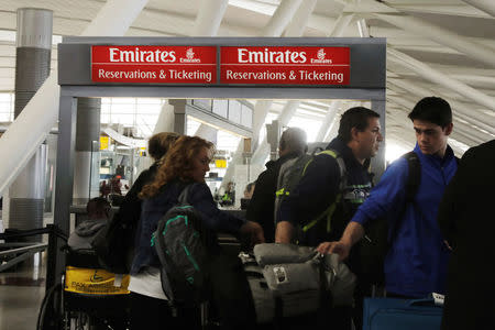 Travelers walk past an Emirates Airlines ticket desk at JFK International Airport in New York, U.S., March 21, 2017. REUTERS/Lucas Jackson