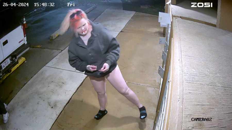 A suspect is seen with with pink hair and tattoos.