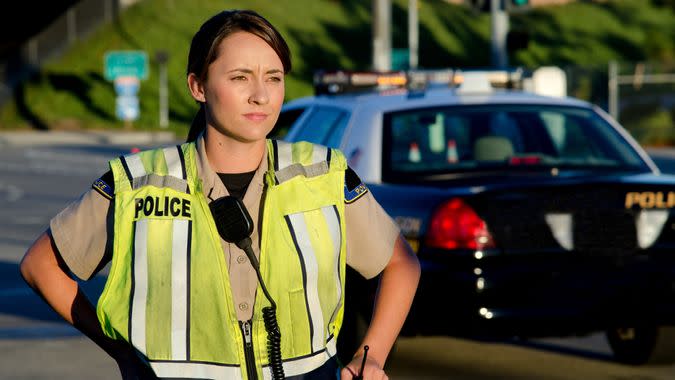 A female police officer staring and looking serious during a traffic control shift.