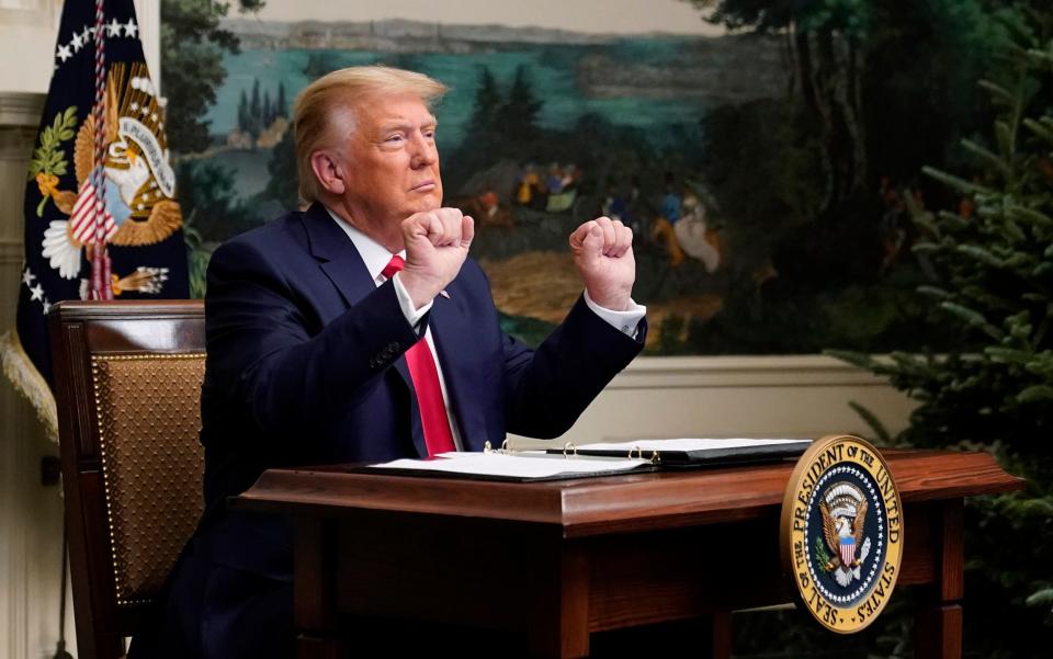 President Donald Trump gestures as he participates in a video teleconference call with members of the military on Thanksgiving - AP