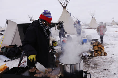 Campers cook lunch inside of the Oceti Sakowin camp as "water protectors" continue to demonstrate against plans to pass the Dakota Access pipeline near the Standing Rock Indian Reservation, near Cannon Ball, North Dakota, U.S., December 2, 2016. REUTERS/Lucas Jackson