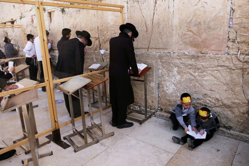 Ultra-Orthodox Jewish boys play as men pray in front of the Western Wall, Judaism's holiest prayer site, in Jerusalem's Old City