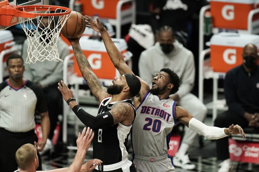 Los Angeles Clippers' Marcus Morris Sr., left, shoots under defense by Detroit Pistons' Josh Jackson during the first half of an NBA basketball game Sunday, April 11, 2021, in Los Angeles. (AP Photo/Jae C. Hong)