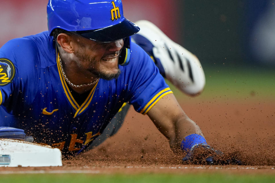 Seattle Mariners' Julio Rodríguez dives back to first base against the Boston Red Sox after a lineout by Mitch Haniger during the fourth inning of a baseball game Friday, March 29, 2024, in Seattle. (AP Photo/Lindsey Wasson)