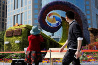 A woman takes pictures of a flower installation marking the Belt and Road Forum in Beijing, China April 25, 2019. REUTERS/Florence Lo