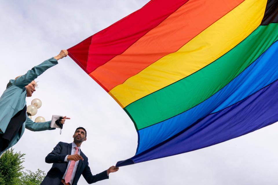 Energy Secretary Jennifer Granholm and Department of Energy Chief of Staff Tarak Shah, right, help raise the Progress Pride Flag outside the Department of Energy in Washington, Wednesday, June 2, 2021. Shah is the first person of color, first Indian-American and first openly LGBTQ person to serve as Chief of Staff for D.O.E.