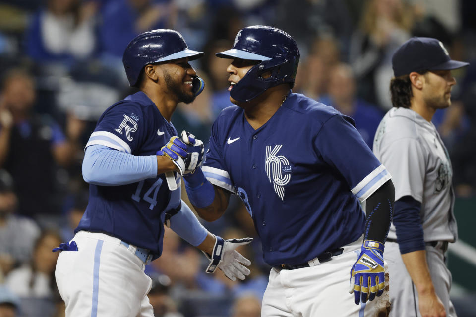 Kansas City Royals' Edward Olivares (14) congratulates Salvador Perez, right, after Perez scored from second off a Vinnie Pasquantino single during the seventh inning of a baseball game against the Seattle Mariners in Kansas City, Mo., Friday, Sept. 23, 2022. (AP Photo/Colin E. Braley)