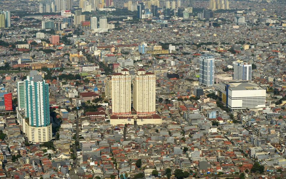  zipping over monster traffic jams, ramshackle red-roofed houses and skyscrapers - AFP