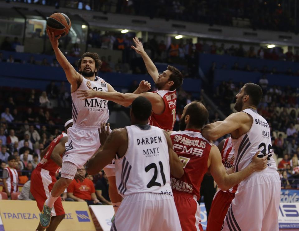 Olympiakos' Vangelis Mantzaris, right, jumps to stop Real Madrid's Sergio Llull during a Euroleague playoff game 3 basketball match at the Peace and Friendship Arena in Athens' port of Piraeus on Monday, April 21, 2014. (AP Photo/Thanassis Stavrakis)