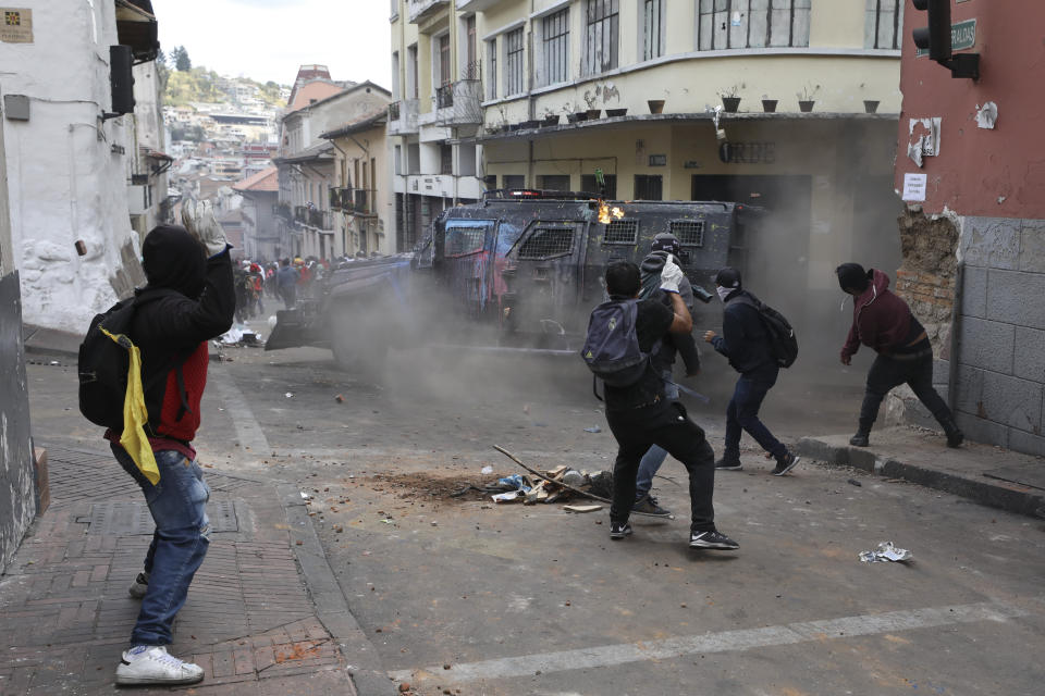 A petrol bomb bounces off an armored vehicle as it turns a corner in chase of protesters during clashes in downtown Quito, Ecuador, Wednesday, Oct. 9, 2019. Ecuador's military has warned people who plan to participate in a national strike over fuel price hikes to avoid acts of violence. The military says it will enforce the law during the planned strike Wednesday, following days of unrest that led President Lenín Moreno to move government operations from Quito to the port of Guayaquil. (AP Photo/Fernando Vergara)