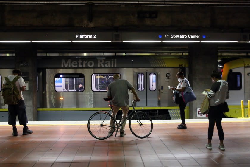 LOS ANGELES, CA - JULY 20: People wait for the blue line at the 7th Street Metro Center on Monday, July 20, 2020 in Los Angeles, CA. Officials reported 2,848 newly confirmed COVID-19 cases on Sunday as hospitalizations have reached a new high. (Dania Maxwell / Los Angeles Times)