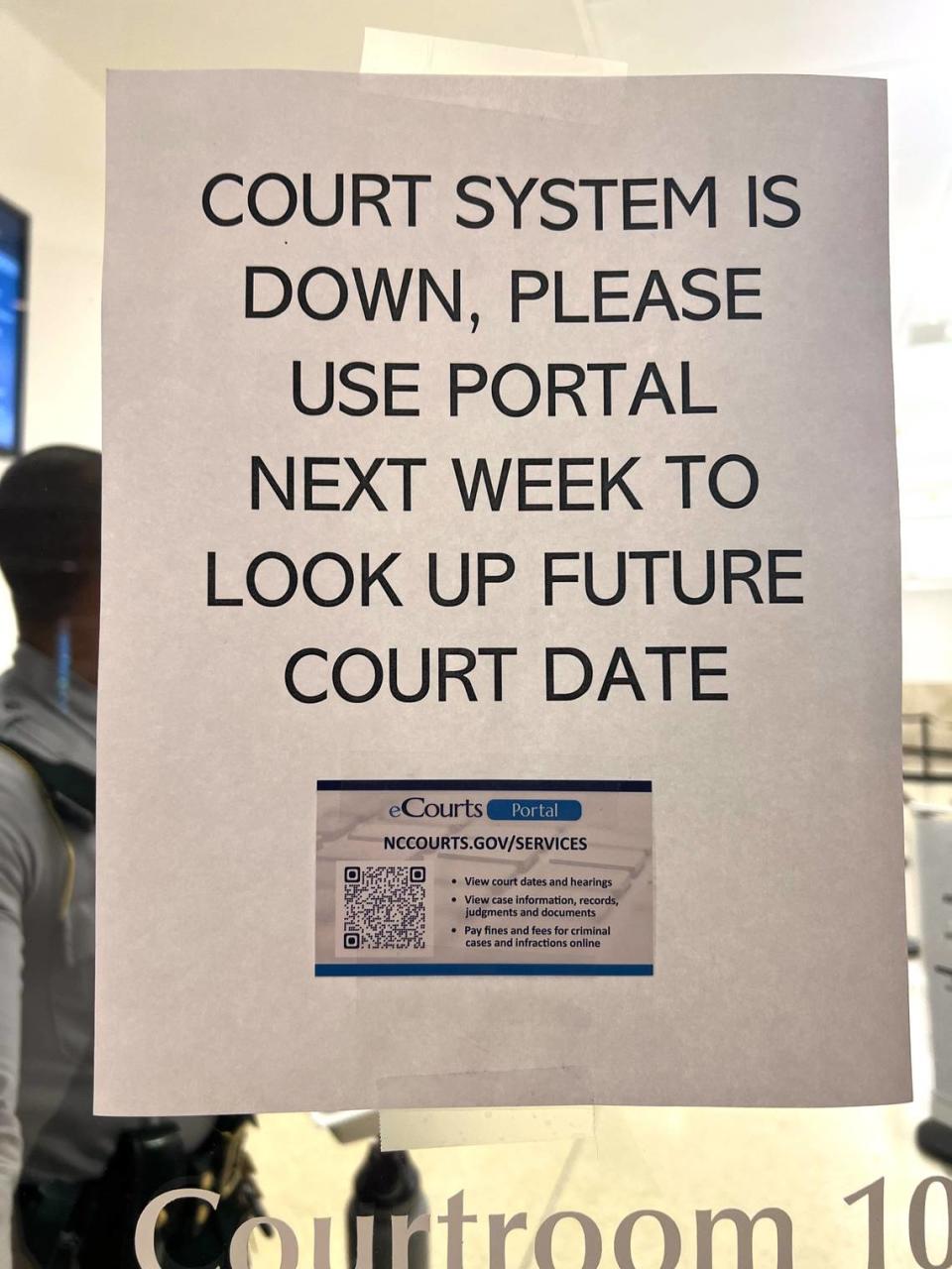 A sign posted outside a Wake County courtroom Sept. 13, 2023, notifies defendants of a problem with the electronic courts system. Wake County District Attorney Lorrin Freeman said she had to send about 60 people waiting for resolution on their cases home because of the problem.