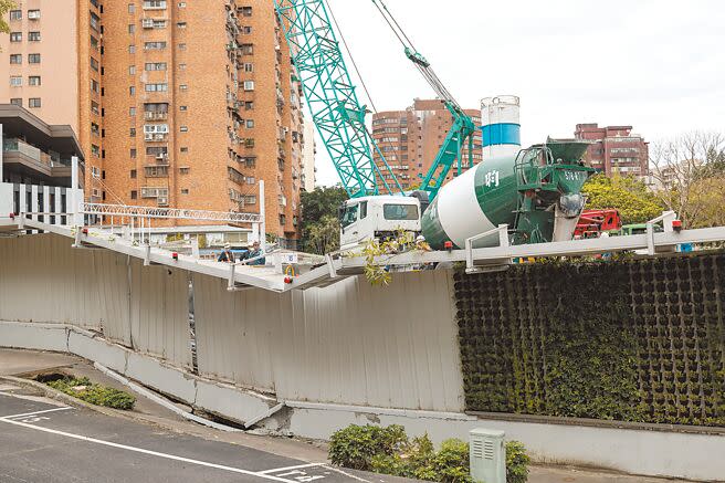 台北市松山區慶城街、興安街口一處工地23日晚間發生地基下陷，造成周邊4台車輛傾斜受損，所幸無人傷亡。市府相關單位獲報後到場釐清，確切塌陷原因待調查。圖為事故現場由工程車載運水泥持續回填灌漿，待基地內側灌漿完成及初凝後，接著外側道路回填。（郭吉銓攝）