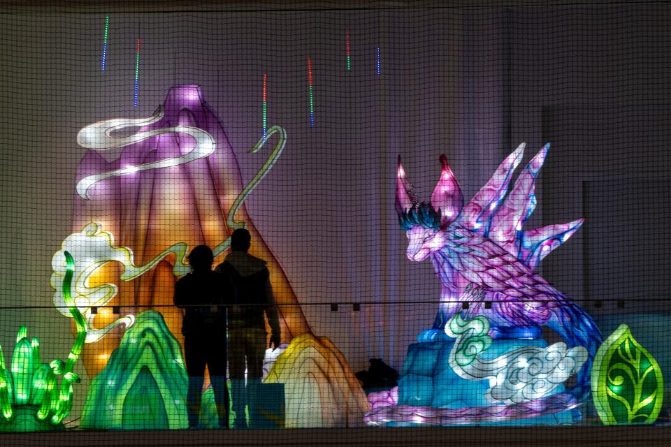 A couple is silhouetted by a volcano at the Winter Lantern Festival at American Dream on Friday, November 3, 2023.