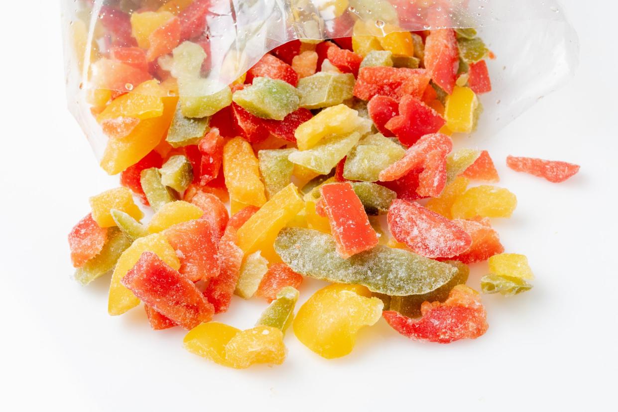 Organic Sliced frozen vegetables (sliced red, yellow and green bell peppers) on white background