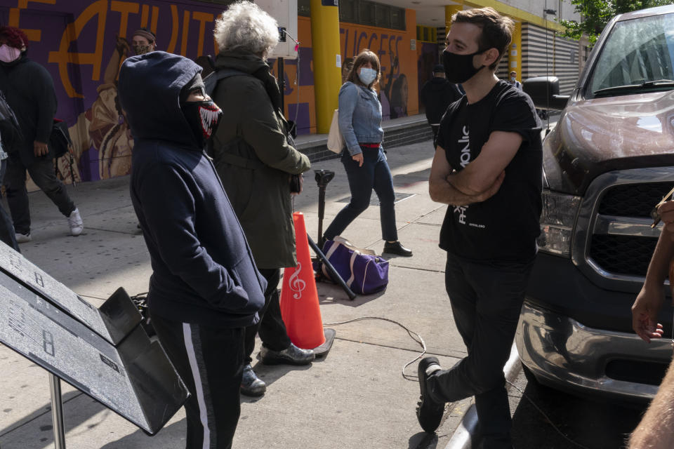 El productor y contratenor del NY Phil Bandwagon Anthony Roth Costanzo, a la derecha, habla con una joven espectadora tras un concierto ante el Centro Educativo y Artístico Casita Maria en Hunts Point, en el barrio neoyorquino del Bronx, el viernes 2 de octubre de 2020. El equipo hizo tres conciertos no anunciados en rincones de la ciudad de Nueva York entre el viernes y el domingo, ofreciendo música de cámara dentro de las actividades de otoño de la orquesta. (AP Foto/Mary Altaffer)