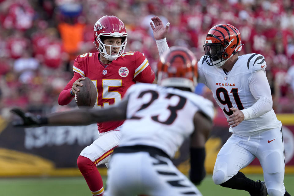 Kansas City Chiefs quarterback Patrick Mahomes (15) scrambles as Cincinnati Bengals defensive end Trey Hendrickson (91) and cornerback Dax Hill (23) defend during the second half of an NFL football game Sunday, Sept. 15, 2024, in Kansas City, Mo. (AP Photo/Ed Zurga)