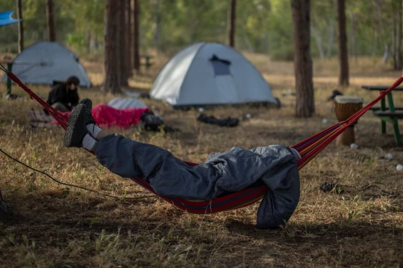 An Israeli right-wing activist is sleeping ahead of a march into the Gaza Strip by activists and some relatives of hostages held by Hamas. Ilia Yefimovich/dpa