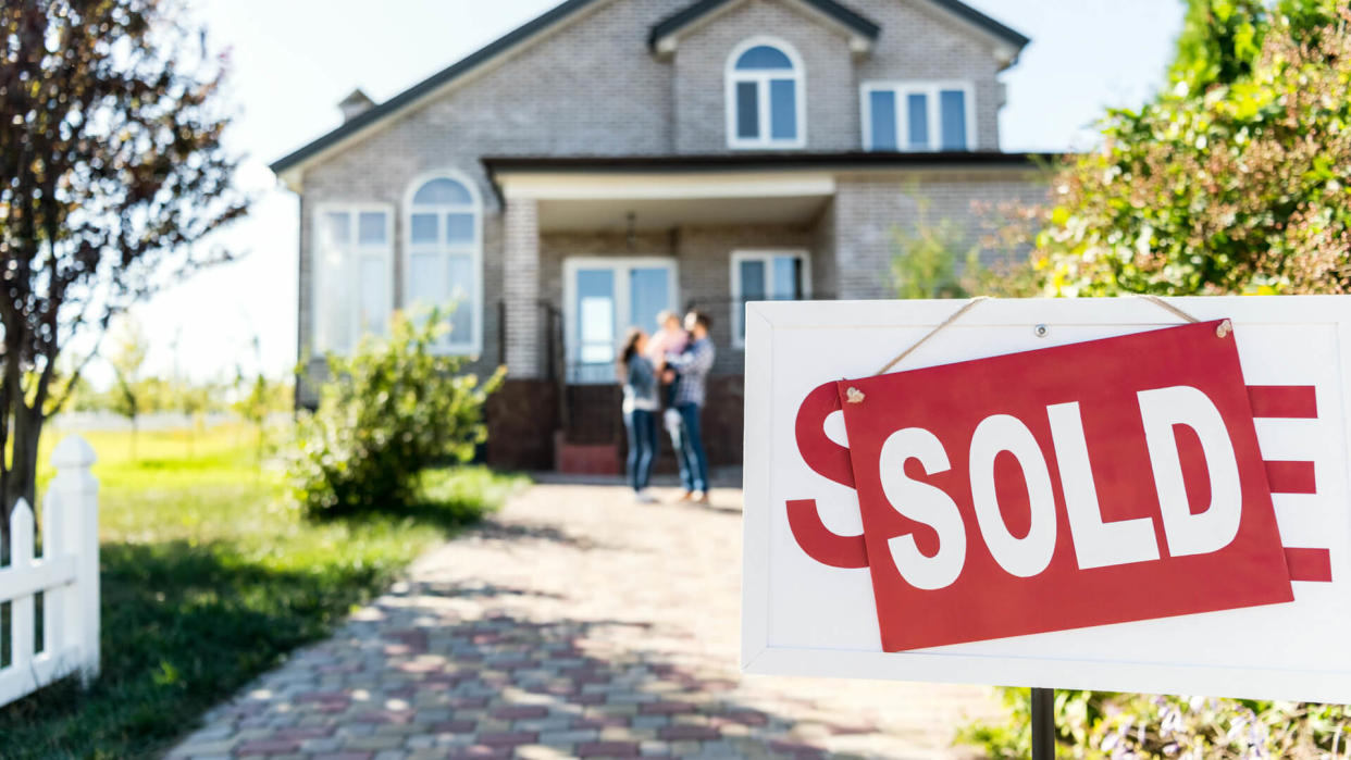 sold house with blurred family on background.