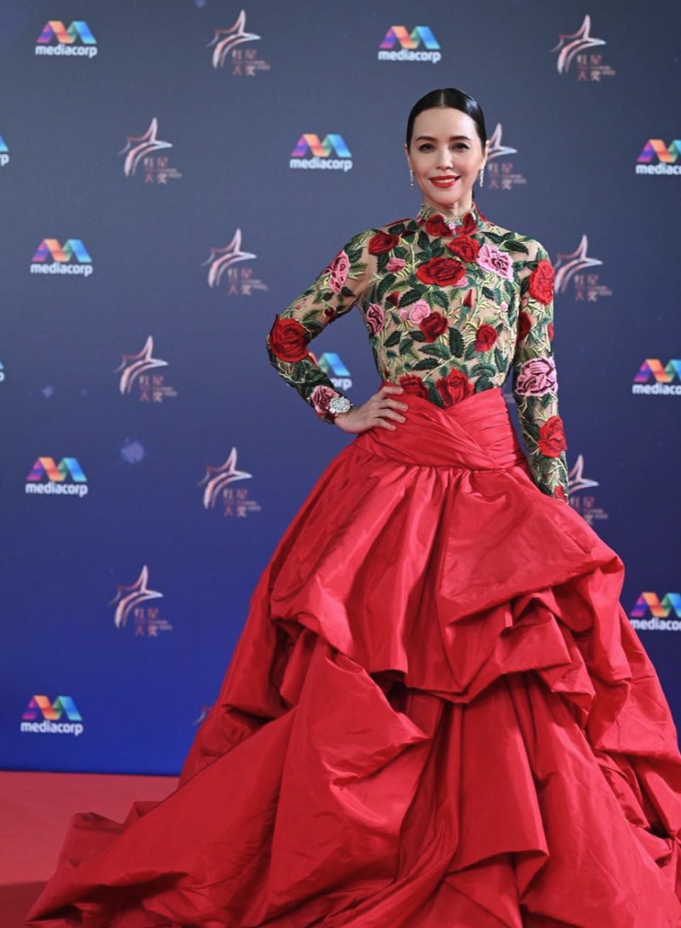 Actress Zoe Tay wore a timeless Tiered Floral Appliqué Gown from Oscar De La Renta on the red carpet with an embroidered floral appliqué bodice and complementary tiered silk-faille skirt, followed by a vintage Christian Lacroix lace and velvet gown to present the award for Top 10 Most Popular Male Artistes. She also wore Cartier jewellery and a Frank Muller watch. Her stylist Johnny Khoo worked with luxury resale marketplace Vestiaire Collective for this timeless look.