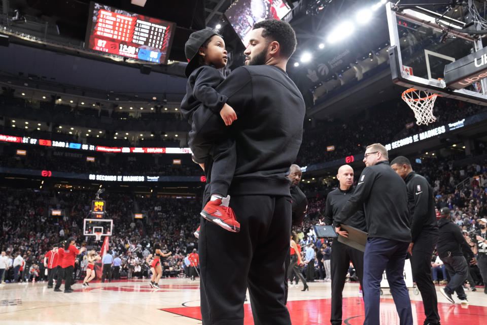 Toronto Raptors guard Fred VanVleet (23) holds his 4-old-daughter, Sanaa Marie, late in the second half of the team's NBA basketball game against the Philadelphia 76ers in Toronto, Thursday, April 7, 2022. (Frank Gunn/The Canadian Press via AP)
