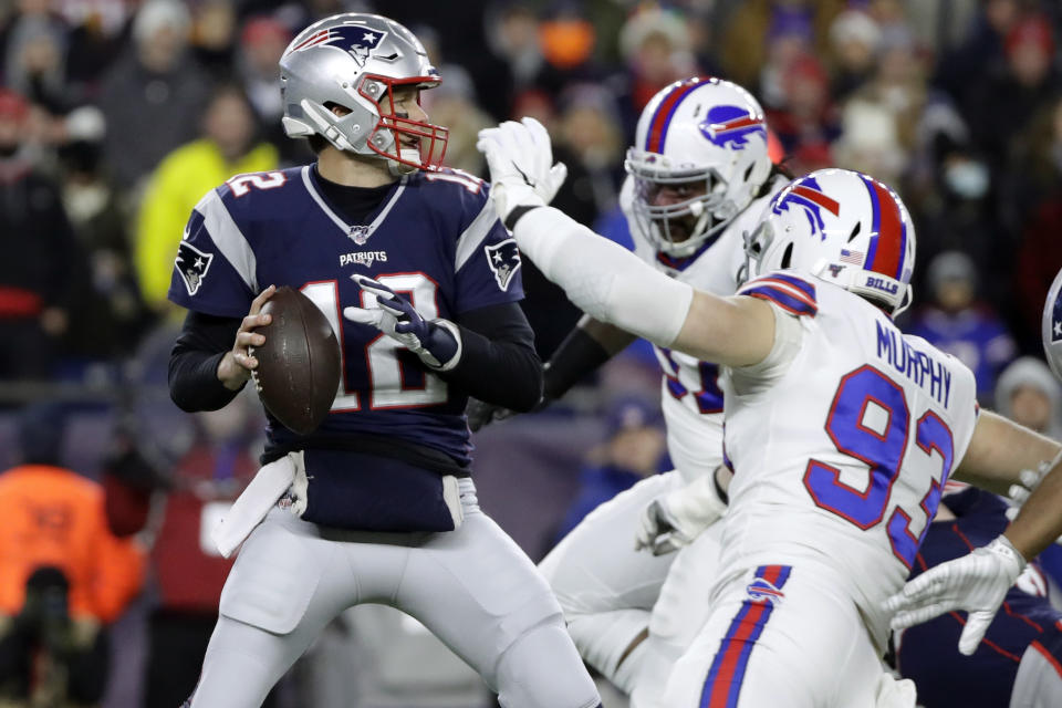 FILE - In this Dec. 21, 2019, file photo, New England Patriots quarterback Tom Brady, left, passes under pressure from Buffalo Bills defensive end Trent Murphy (93) during the first half of an NFL football game in Foxborough, Mass. Between them, Brady and Drew Brees have played 38 pro football seasons, 39 if you count 2008 when the New England star wrecked his knee in Week 1,  and could be doing so against each other on Feb. 2 in a little thing called the Super Bowl. (AP Photo/Elise Amendola, File)