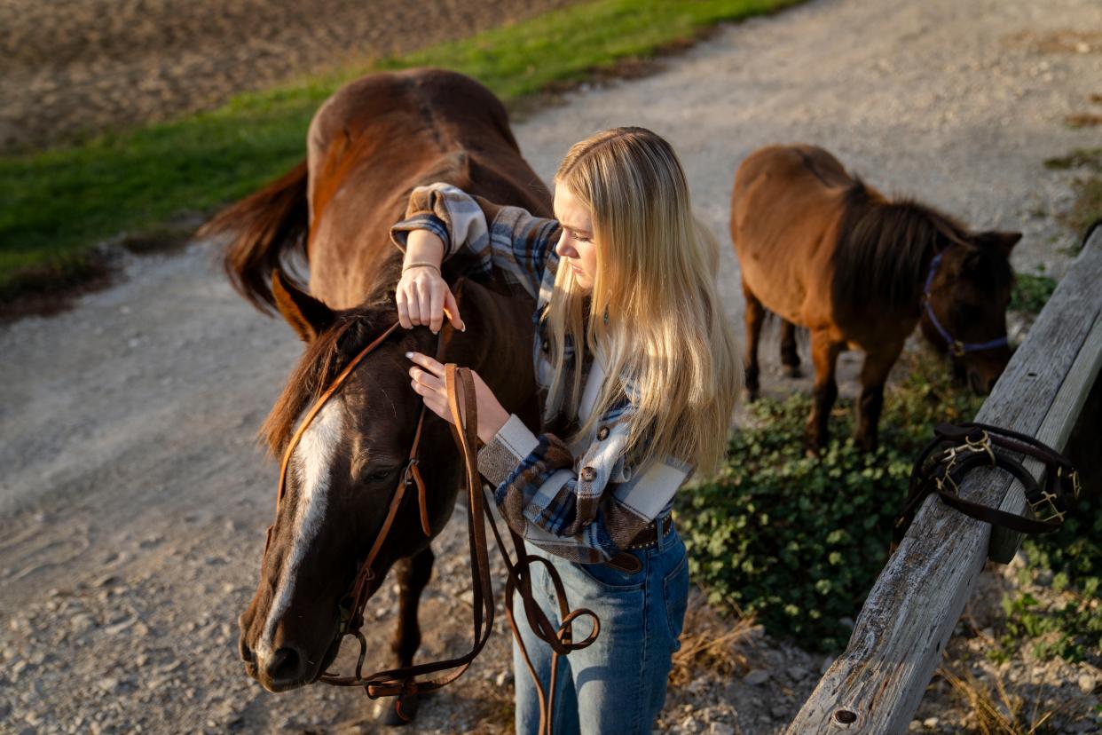 Elivia gets ready to ride her horse, Chicken.