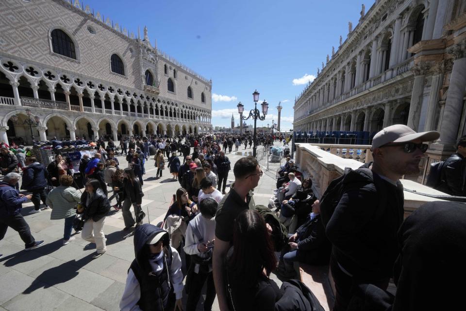 Tourists line up to enter at the at St.Mark bell tower in Venice, Italy, Thursday, April 25, 2024. The fragile lagoon city of Venice begins a pilot program Thursday to charge daytrippers a 5 euro entry fee that authorities hope will discourage tourists from arriving on peak days. (AP Photo/Luca Bruno)